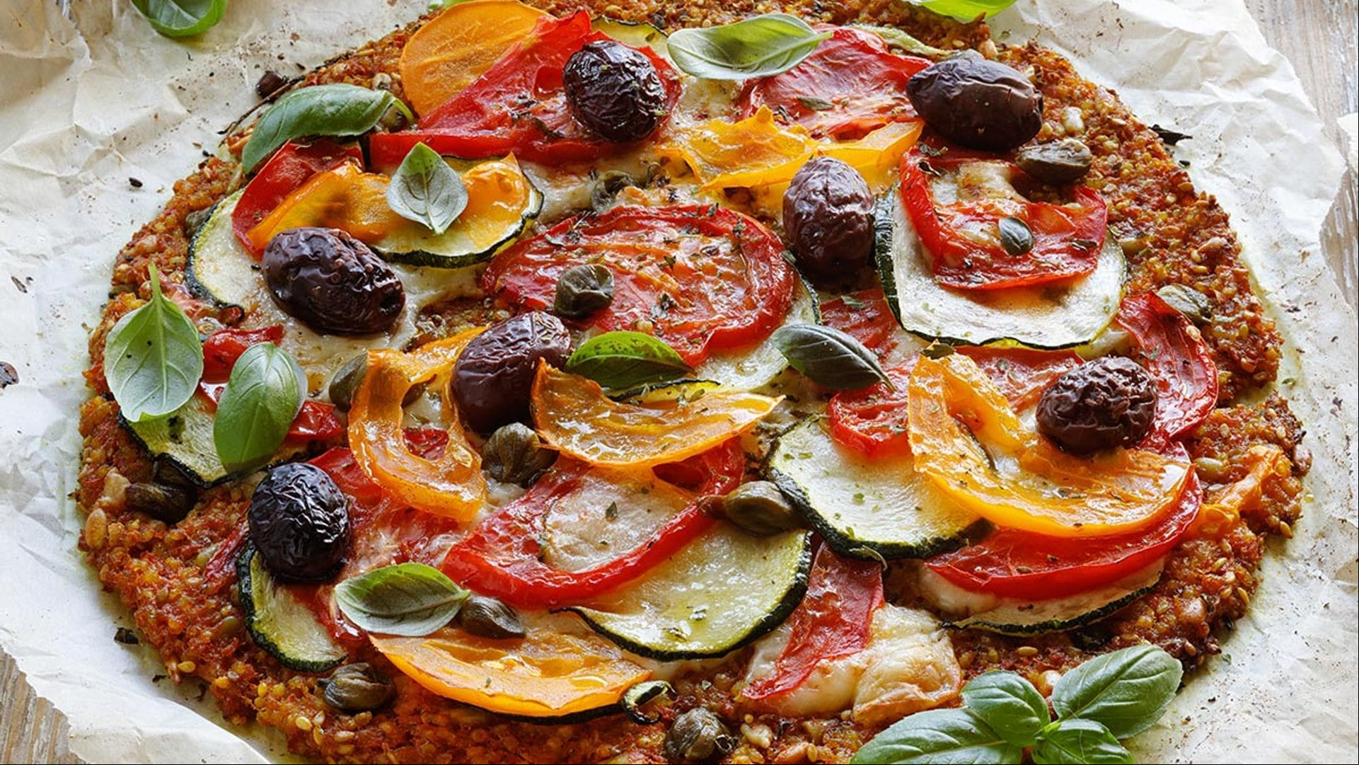 Pizza de zanahoria con tomate, calabacín y aceitunas
