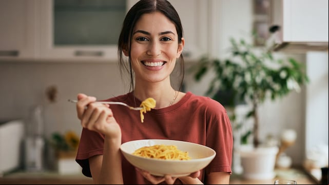 Mujer comiendo espagueti