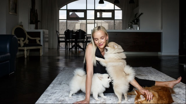 Mujer jugando con sus perros y gato