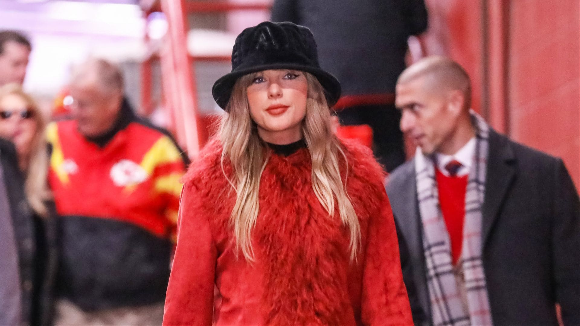 Taylor Swift sorprende en el partido de fútbol de su novio con maxiabrigo rojo y botas de tacón españolas