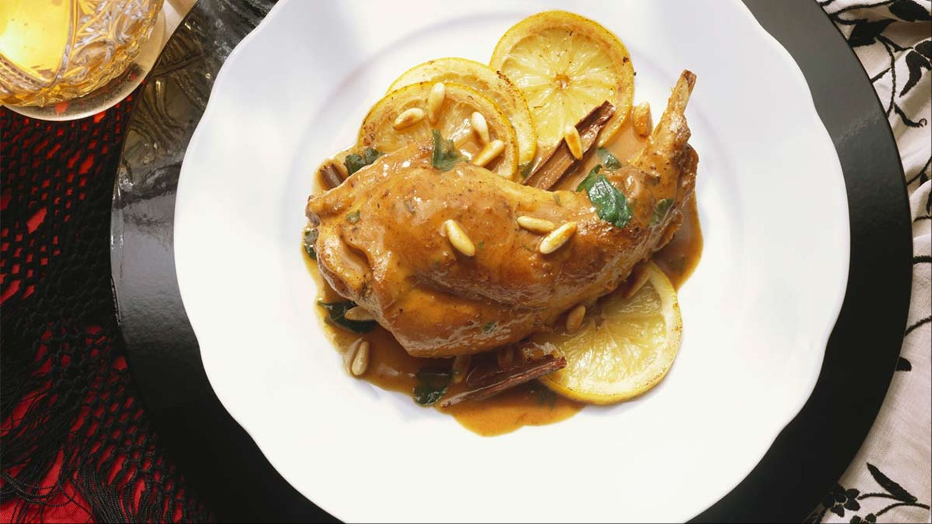 Muslos de conejo asados con limón y piñones
