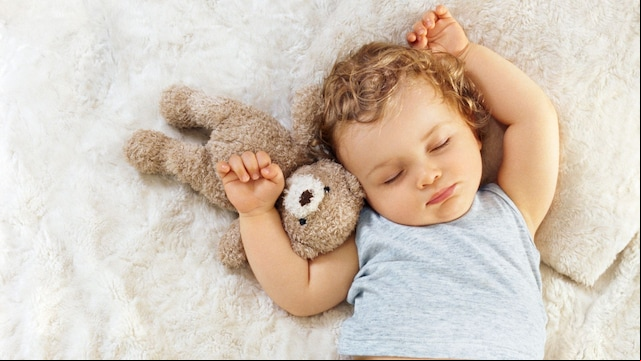 Niña durmiendo en la cama plácidamente con su osito de peluche