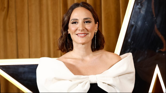 Tamara Falcó en el photocall del programa Got Talent con vestido de decote barco y maxilazo blanco