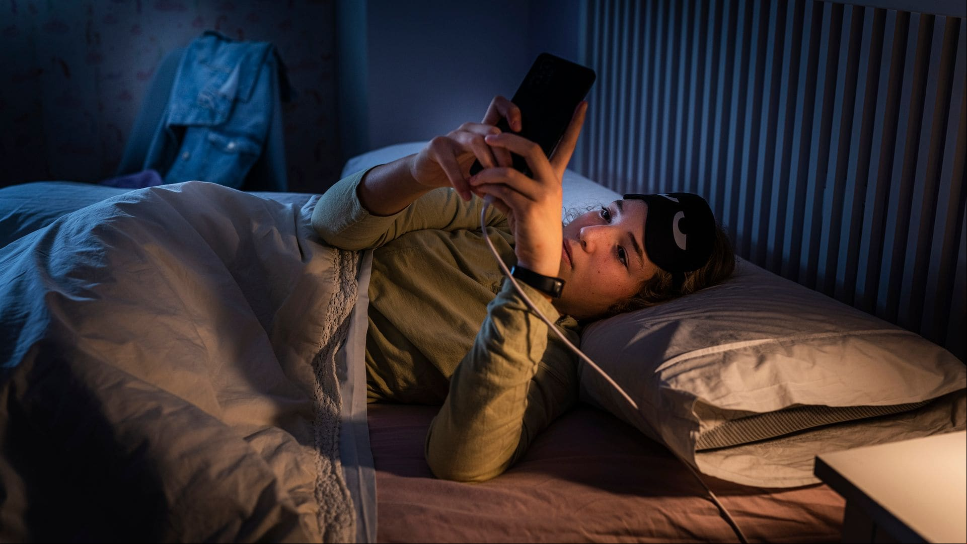 Adolescente que sufre trastornos del sueño usando un smartphone por la noche