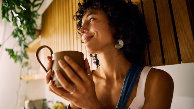 Mujer tomando una infusión en su cocina