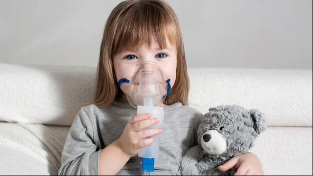 Niña con asma con un nebulizador