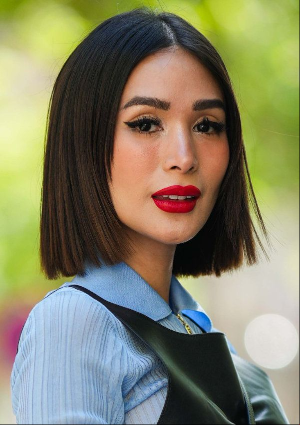 Heart Evangelista con labial rojo, camisa azul y melena lisa