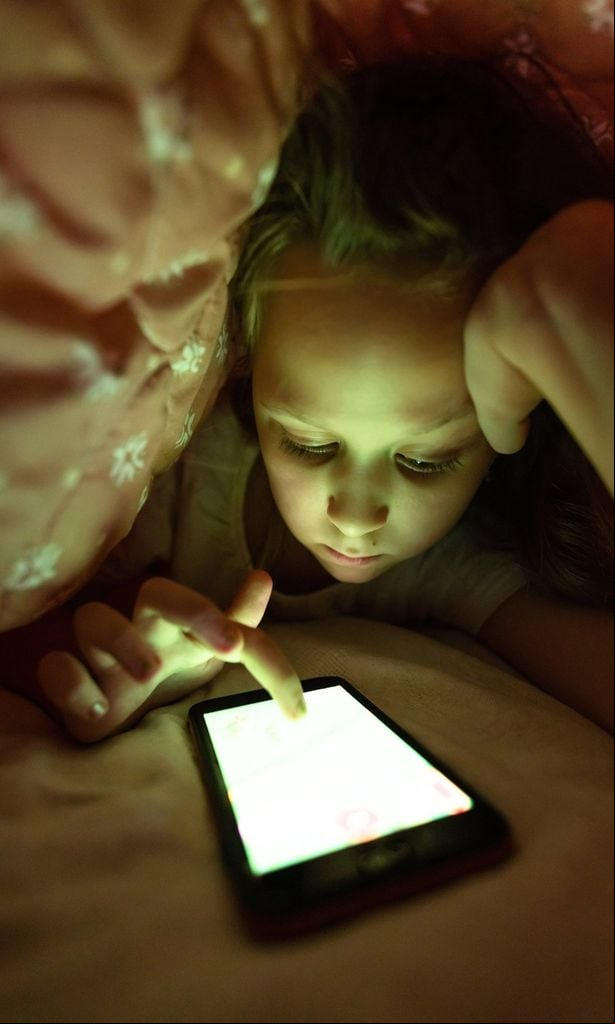Niña con pantallas de noche