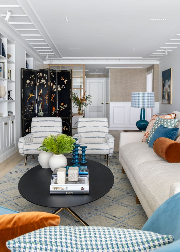 Salón con sofá blanco y dos butacas con estampado de rayas