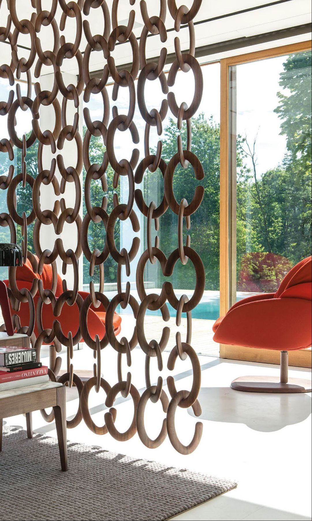 Salón separado por una pantalla de círculos de madera