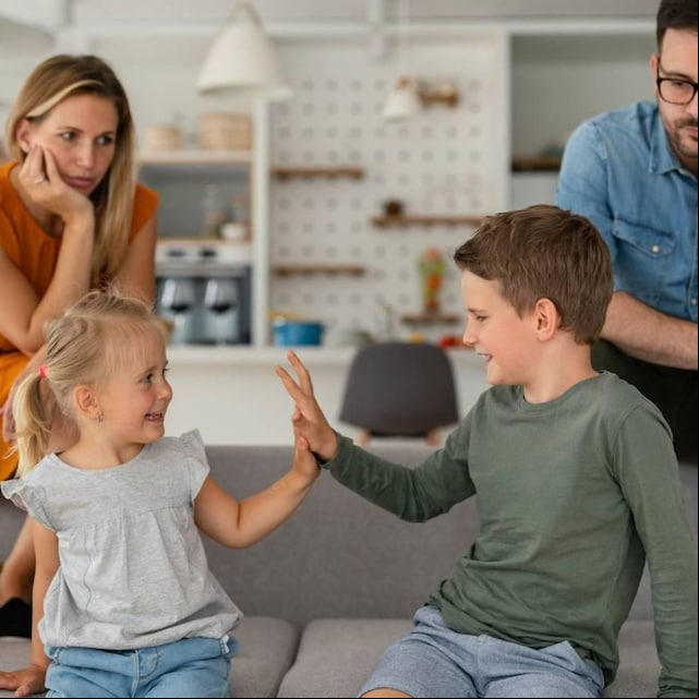 padres resignados viendo a sus hijos chocar las manos felices