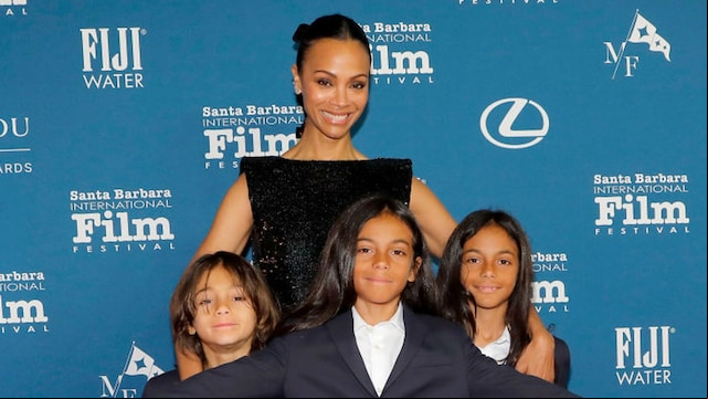 Zoe Saldaña poses with her three sons on the red carpet at the Santa Barbara International Film Festival, all dressed in coordinated navy-blue suits