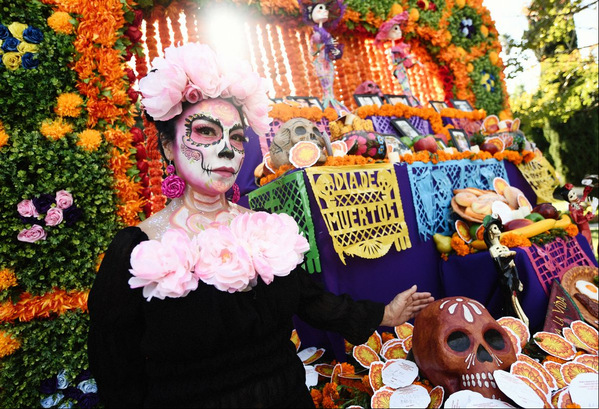 An attendee in costume poses at an altar during the Hollywood Forever Presents Dia De Los Muertos Celebration at Hollywood Forever on October 26, 2024 in Hollywood, California. (Photo by Chelsea Guglielmino/Getty Images)